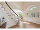 Grand foyer featuring a staircase, hardwood floors, and an arched transom window at 5331 S Geneva Way, Englewood, CO 80111