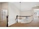 Upstairs hallway featuring a decorative railing, chandelier, and neutral carpet at 5331 S Geneva Way, Englewood, CO 80111