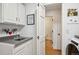 Bright laundry room with washer and dryer, sink, cabinetry, and access to the bathroom at 5331 S Geneva Way, Englewood, CO 80111