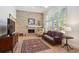Cozy living room with a brick fireplace, high ceilings, and shuttered windows at 5331 S Geneva Way, Englewood, CO 80111