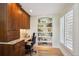 Home office with custom built-ins, a window with plantation shutters, and natural light at 5331 S Geneva Way, Englewood, CO 80111