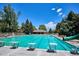 An expansive outdoor swimming pool, perfect for recreation, with surrounding greenery and lounge area at 5331 S Geneva Way, Englewood, CO 80111