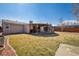 Expansive backyard featuring a covered patio, stone fireplace, and a well-maintained lawn at 4909 W Mississippi Ave, Denver, CO 80219