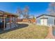 Well-maintained backyard with a covered patio, stone fireplace, storage shed, and garden features at 4909 W Mississippi Ave, Denver, CO 80219