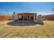 Spacious backyard featuring a covered patio with an outdoor kitchen and a stone fireplace at 4909 W Mississippi Ave, Denver, CO 80219