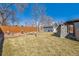 Lush backyard with mature trees, garden decor, storage shed and covered patio with stone fireplace at 4909 W Mississippi Ave, Denver, CO 80219