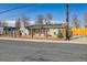 Inviting home exterior showcases a fenced front yard, solar panels, well-maintained lawn, and mature trees at 4909 W Mississippi Ave, Denver, CO 80219