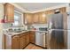 Well-lit kitchen features stainless steel appliances, light wood cabinets, and durable marble-look countertops at 4909 W Mississippi Ave, Denver, CO 80219