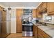 Kitchen features a stainless steel range and microwave, light wood cabinets and a marble-look countertop at 4909 W Mississippi Ave, Denver, CO 80219