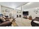 Cozy living room space with neutral carpet, sectional couch, and flat screen tv at 4909 W Mississippi Ave, Denver, CO 80219