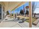 Inviting front porch, with potted plants, featuring a mature tree and a view of the neighborhood at 4909 W Mississippi Ave, Denver, CO 80219