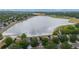 Aerial view of a serene lake surrounded by green trees and residential homes with solar panels at 8738 Chase Dr # 134, Arvada, CO 80003