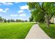 Lush green space with mature trees and a paved walking path at 8738 Chase Dr # 134, Arvada, CO 80003