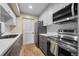 Efficient galley kitchen features gray lower cabinets, white upper cabinets, and stainless appliances at 8738 Chase Dr # 134, Arvada, CO 80003