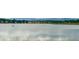 Tranquil lake view reflecting the sky, surrounded by lush greenery, homes, and mountains in the distance at 8738 Chase Dr # 134, Arvada, CO 80003