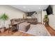 Comfortable living room featuring hardwood floors, a sectional couch, and access to the stairway at 8738 Chase Dr # 134, Arvada, CO 80003