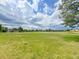 Expansive green field under a bright, cloudy sky, offering plenty of space for recreation and activities at 8738 Chase Dr # 134, Arvada, CO 80003