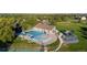 Aerial view of community pool and playground surrounded by mature trees and greenery at 8738 Chase Dr # 134, Arvada, CO 80003
