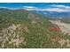 Aerial view of the cabin surrounded by lush forest and mountain vistas at 23778 Inca Rd, Indian Hills, CO 80454