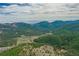 Breathtaking aerial view with mountain views and lush forests surrounding scattered homes at 23778 Inca Rd, Indian Hills, CO 80454