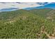 High altitude aerial view shows thick tree cover of the surrounding area at 23778 Inca Rd, Indian Hills, CO 80454