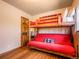 bedroom with a bunk bed, wood floors, and a wood door at 23778 Inca Rd, Indian Hills, CO 80454