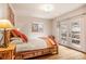 Bright bedroom offers a rustic wood bed frame and access to outdoor patio at 23778 Inca Rd, Indian Hills, CO 80454