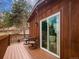 Exterior view of a wooden deck with furniture and a sliding glass door at 23778 Inca Rd, Indian Hills, CO 80454