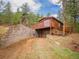Cabin exterior with garage, wooden deck, and stone accents at 23778 Inca Rd, Indian Hills, CO 80454