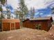 Side view of the home with matching shed and ample storage at 23778 Inca Rd, Indian Hills, CO 80454