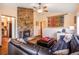 Inviting living room featuring a stone fireplace, leather couch, and wood floors at 23778 Inca Rd, Indian Hills, CO 80454
