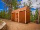 Exterior of a wood shed nestled among mature pine trees at 23778 Inca Rd, Indian Hills, CO 80454