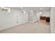 Finished basement with carpet, built in shelving, and doorway with access to a kitchenette at 4130 Umatilla St, Denver, CO 80211