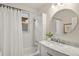 Bright bathroom with white subway tile, marble vanity, round mirror, and tub/shower combo at 4130 Umatilla St, Denver, CO 80211