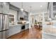Modern kitchen with stainless steel appliances, gray cabinets, marble countertops, and open layout at 4130 Umatilla St, Denver, CO 80211