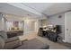 Spacious basement area featuring neutral walls, comfortable couch, and a dedicated workspace for creative pursuits at 15157 E Nassau Ave, Aurora, CO 80014