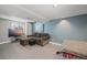 Inviting basement space with blue accent wall, comfortable couch, and entertainment center for relaxation and leisure at 15157 E Nassau Ave, Aurora, CO 80014
