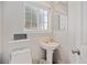 Clean half-bathroom with a pedestal sink and a window providing natural light at 15157 E Nassau Ave, Aurora, CO 80014