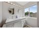 Bright bathroom featuring dual sinks, ample counter space, and a window for natural light at 15157 E Nassau Ave, Aurora, CO 80014