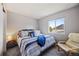 Comfortable bedroom featuring a plush bed with striped bedding and a cozy armchair at 15157 E Nassau Ave, Aurora, CO 80014