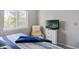 A cozy bedroom features a comfortable chair, TV, and a bright window overlooking greenery at 15157 E Nassau Ave, Aurora, CO 80014