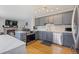 Modern kitchen boasts stainless steel appliances, island with stone countertop, and gray cabinets at 15157 E Nassau Ave, Aurora, CO 80014
