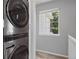 Efficient laundry area with stackable washer and dryer and a bright window for natural light at 15157 E Nassau Ave, Aurora, CO 80014