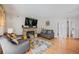Cozy living room featuring a brick fireplace, hardwood floors, and neutral-colored furniture at 15157 E Nassau Ave, Aurora, CO 80014