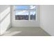 Minimalist bedroom with large window and neutral carpet offers ample natural light and a serene atmosphere at 8 Oneida Ct, Denver, CO 80230