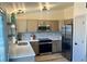 Updated kitchen featuring stainless steel appliances, modern backsplash, and wood cabinets at 1488 S Biscay Ct, Aurora, CO 80017