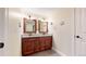 This bathroom boasts a dual sink vanity with granite countertop and decorative mirrors at 1724 Silverado Ln, Fort Lupton, CO 80621