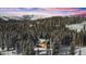 Aerial view of a log cabin nestled in a snowy mountain forest at 229 Lee Ln, Breckenridge, CO 80424