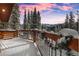 Snow covered deck with hot tub and stunning mountain views at sunset at 229 Lee Ln, Breckenridge, CO 80424