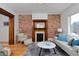 Bright living room featuring exposed brick, decorative fireplace, and hardwood floors at 608 S Grant St, Denver, CO 80209